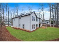 White two-story home with a well-maintained lawn and black trim around windows at 4352 Riverlake Way, Snellville, GA 30039