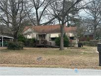 Modest home with mature trees, side carport, and accessible front entrance at 8482 Fairview Dr, Douglasville, GA 30134