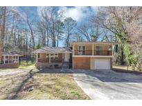 Split-level home with a front porch, upper level balcony, attached garage and a nice yard at 389 Harlan Sw Rd, Atlanta, GA 30311