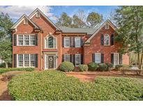 Elegant brick home featuring manicured landscaping, symmetrical design, and a welcoming entrance at 1558 Amberwood Creek Nw Dr, Kennesaw, GA 30152