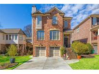 Charming two-story brick home with manicured front yard, two-car garage, and beautiful architectural details at 2348 Loraine Street Ne St, Atlanta, GA 30319