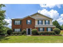 Charming two-story home featuring a brick facade, well-manicured lawn, and colorful landscaping at 2974 Michelle Lee Dr, Dacula, GA 30019