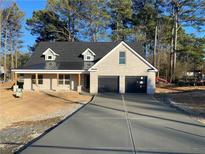 Charming brick home with a modern black roof, two-car garage, and a spacious concrete driveway at 1883 Bennett Rdg, Snellville, GA 30078