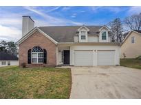 Charming two-story home featuring a brick accent, vinyl siding, and a convenient two-car garage at 5589 Claridge Cir, Lithonia, GA 30038