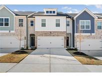 Charming townhome featuring a two-car garage, brick accents, and neutral color palette at 5611 Hislop Lane # 81, Mableton, GA 30126
