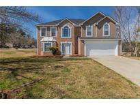 Charming two-story home features brick and siding, a well-manicured lawn and attached two-car garage at 4060 Rockmill Cv, Ellenwood, GA 30294