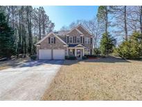 Charming two-story brick home with attached two-car garage, landscaped yard, and mature trees at 2100 Caneridge Sw Dr, Marietta, GA 30064