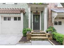 Charming front entrance featuring stone steps, a covered porch, and green shingle siding at 2421 Saint Davids Nw Sq, Kennesaw, GA 30152