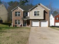 Two-story brick home featuring a two-car garage and a well-maintained front yard at 6809 Ridgewood Ln, Riverdale, GA 30296