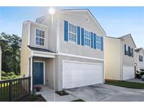 Charming two-story home with blue shutters, a white garage door, and a well-maintained lawn at 5446 Waterfall Ct, Atlanta, GA 30349