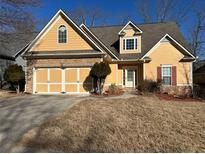 Charming yellow home with a stone-accented facade and well-maintained lawn at 9996 Village South Dr, Douglasville, GA 30135