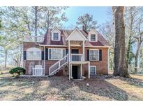 Charming brick home with a cozy front porch, dormer windows, and a unique rooftop deck at 238 Howell Sw Dr, Atlanta, GA 30331