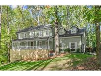 Charming two-story home with a welcoming front porch and a well-manicured lawn at 275 Waverly W Trce, Roswell, GA 30075