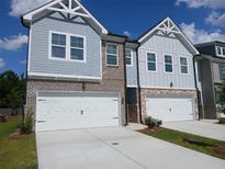 Charming townhome with blue siding, brick accents, and a two-car garage, perfect for modern living at 344 Sinclair Ct # 74, Mcdonough, GA 30253