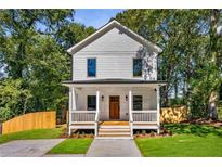 Charming two-story home featuring a welcoming front porch, fresh landscaping, and a classic white facade at 891 Thurmond Nw St, Atlanta, GA 30314