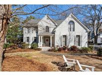 Charming two-story white brick home with a manicured front lawn and inviting entrance, perfect for a Gathering at 4919 Riverhill Ne Rd, Marietta, GA 30068