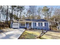 Charming single-story home features a well-manicured lawn, blue siding and an attached one-car garage at 6299 Valdez Dr, Rex, GA 30273
