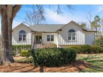 Charming home featuring a manicured lawn, complemented by mature trees and verdant shrubbery at 2280 Lansdowne Dr, Canton, GA 30115