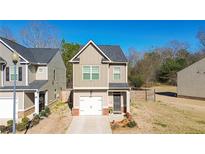 Charming two-story home featuring a well-manicured lawn, single-car garage and neutral-colored exterior at 375 Milton Dr, Covington, GA 30016