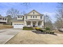 Charming two-story home with manicured landscaping and inviting front porch at 208 Park Pointe Way, Suwanee, GA 30024