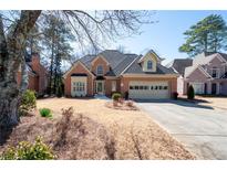 Charming brick home featuring a well-manicured lawn and attached two-car garage at 3042 Kalah Se Pl, Marietta, GA 30067