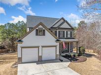 Charming two-story home with a well-manicured lawn and a two-car garage at 237 Elmbrook Ln, Canton, GA 30114