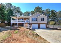 Charming home with a covered porch, two-car garage, and well-maintained lawn and mature landscaping at 26 Wey Bridge Ct, White, GA 30184