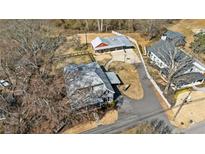 Expansive aerial view showcases a charming property with multiple buildings, mature trees, and winding driveway at 527 Main St, Suwanee, GA 30024