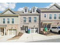 Charming gray brick townhome with two-car garage, dormer windows, and inviting curb appeal at 1538 Ridgebrook Downs, Mableton, GA 30126