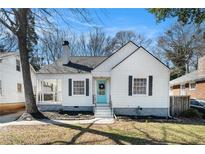Charming white cottage-style home featuring a covered porch and a light blue front door at 1547 Melrose Sw Dr, Atlanta, GA 30310