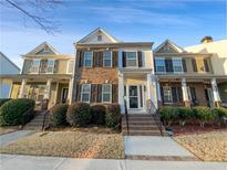 Charming townhome with brick and siding exterior, manicured landscaping and welcoming front porch at 1235 Park Pass Way, Suwanee, GA 30024