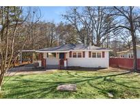 Charming single-story home with freshly cut green grass, white brick and brown shutters at 248 N Lake Dr, Jonesboro, GA 30236