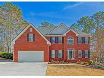 Charming two-story brick home with a well-maintained lawn, attached garage, and beautiful landscaping at 569 Alexander Farms Sw Vw, Marietta, GA 30064