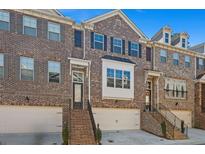 Beautiful brick townhouse with a two-car garage, steps, and windows with dark shutters at 4206 Townsend Ln, Atlanta, GA 30346