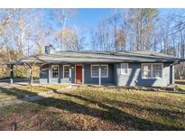 Charming single-story home with a cozy front porch and well-maintained landscaping at 217 Woodglen Dr, Woodstock, GA 30188