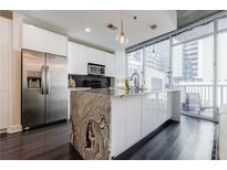 Modern kitchen with stainless steel appliances, marble island, and large windows with city views at 44 Peachtree Ne Pl # 829, Atlanta, GA 30309