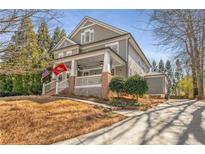 Charming two-story home with a inviting front porch, flags, and well-maintained landscaping at 111 Spruell Springs Dr, Atlanta, GA 30342