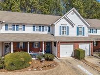 Charming townhome with brick accents, a covered porch, well-manicured landscaping, and attached garage at 330 Cottonwood Creek Cir, Canton, GA 30114