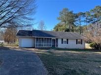 Charming single-story home with a screened-in porch and well-maintained lawn at 3845 Hwy 81 West, Hampton, GA 30228