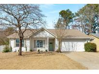 Charming single-story home with a well-manicured front yard and an attached two-car garage at 4820 Roswell Mill Dr, Alpharetta, GA 30022