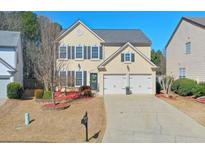 Charming two-story home with a two-car garage and a well-manicured front yard at 495 Stambridge Ct, Johns Creek, GA 30005