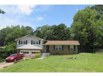 Charming two-story home with a well-maintained lawn, attached garage, and mature trees in a suburban setting at 661 White Bird Way, Fairburn, GA 30213