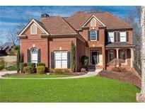 Attractive two-story brick home featuring a lush front lawn and well-maintained landscaping at 1229 Ellington Ct, Cumming, GA 30041