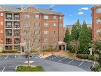Condo building with brick facade, multiple balconies, and a well-maintained parking area at 2300 Peachford Rd # 4004, Atlanta, GA 30338