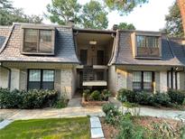 Charming townhome featuring a brick facade, dormer windows, and inviting landscaping at 8 Cantey Nw Pl, Atlanta, GA 30327