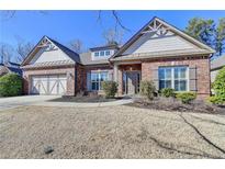 Charming brick home with well-manicured lawn and attached two-car garage at 4830 Amble Trce, Cumming, GA 30040