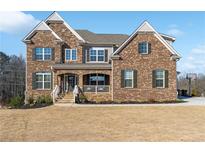 Charming two-story brick home with stone accents and inviting front porch, perfect for enjoying the neighborhood at 6375 Haystack Ct, Cumming, GA 30040