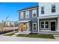 Charming two-story home featuring a welcoming porch, orange front door and modern architectural details at 697 Fayetteville Road, Atlanta, GA 30316