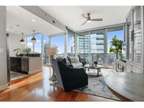 Bright living room featuring hardwood floors, modern lighting, and floor-to-ceiling windows with city views at 1080 Peachtree Ne St # 2807, Atlanta, GA 30309