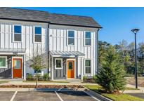 Charming townhome featuring a stylish exterior, landscaped front yard, and a vibrant orange front door at 697 Fayetteville Rd # 303, Atlanta, GA 30316